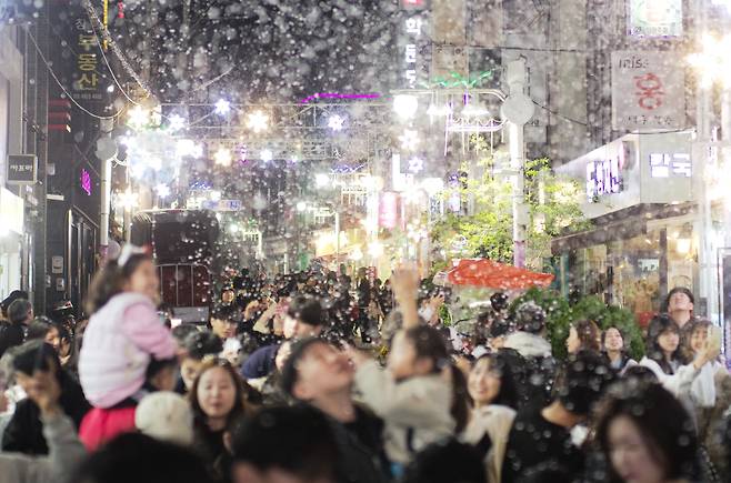 지난 10일 오후 경남 창원시 마산합포구 창동거리에서 '제5회 눈 내리는 창동거리 눈꽃축제'가 열리고 있다. 인공 눈을 내리게 하는 이 행사는 창원시가 후원하고 창동통합상가상인회가 주최한다. /연합뉴스