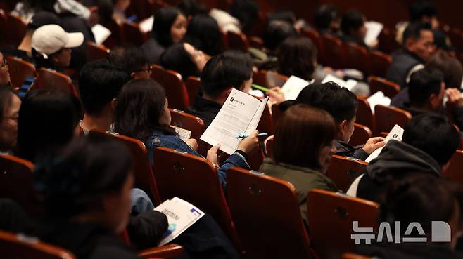 [서울=뉴시스] 추상철 기자 = 17일 서울 영등포구 영등포아트홀에서 열린 '2025학년도 대입정시 지원전략 설명회'에서 학부모들이 정시 모집 관련 책자를 살펴보고 있다. 2024.11.17. scchoo@newsis.com