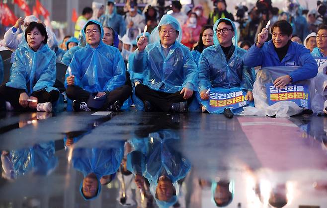 이재명 더불어민주당 대표가 16일 서울 종로구 광화문 앞에서 열린 ’김건희 윤석열 국정농단 규탄·특검 촉구 제3차 국민행동의 날‘ 집회에 참석해 촛불을 들고 앉아있다.    뉴시스