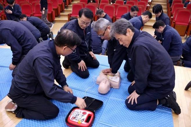 부산교통공사 임직원들이 교육용 마네킹으로 심폐소생술과 자동심장충격기 사용법 등을 실습하고 있다.(가장 오른쪽 이병진 부산교통공사 사장) 부산교통공사 제공