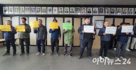 18일 오전 김윤철 경남 합천군수의 기자회견이 열리고 있는 합천군청 대회의실에 지역 주민 10여명이 손피켓을 들고 항의하고 있다. [사진=임승제 기자]