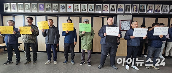 18일 오전 김윤철 경상남도 합천군수의 기자회견이 열리고 있는 군청 3층 대회의실에 지역 주민 10여명이 손피켓을 들고 항의 시위를 벌이고 있다. [사진=임승제 기자]