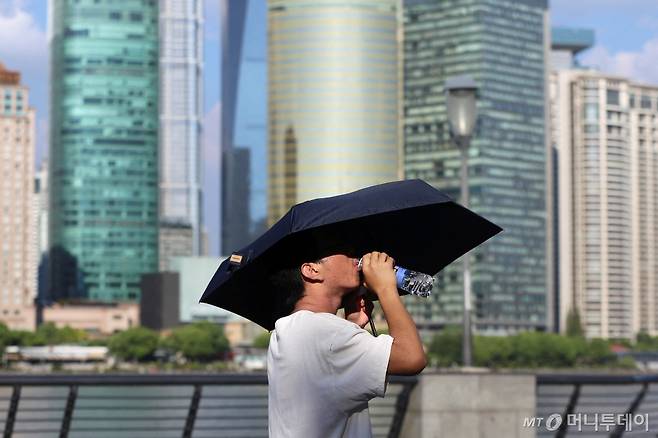 (상하이 로이터=뉴스1) 정지윤 기자 = 무더운 여름을 기록하고 있는 1일 중국 상하이에서 한 남성이 양산을 쓴 채 물을 마시고 있다. 2024.08.01 ⓒ 로이터=뉴스1 Copyright (C) 뉴스1. All rights reserved. 무단 전재 및 재배포, AI학습 이용 금지. /사진=(상하이 로이터=뉴스1) 정지윤 기자