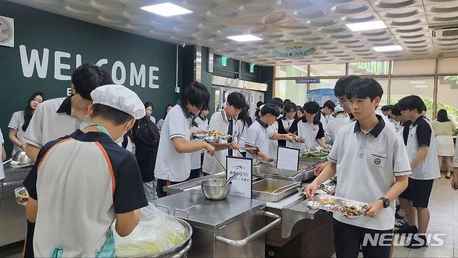 [수원=뉴시스] 17일 오후 경기 화성시 동탄중학교 급식실에서 학생들이 점심식사를 먹기 위해 식판에 음식을 담고 있다. 동탄중은 지난해 1학기부터 임태희 교육감 취임 이후 도입된 자율선택급식을 운영 중이다. (사진=경기도교육청 제공) 2024.07.17. pjd@newsis.com