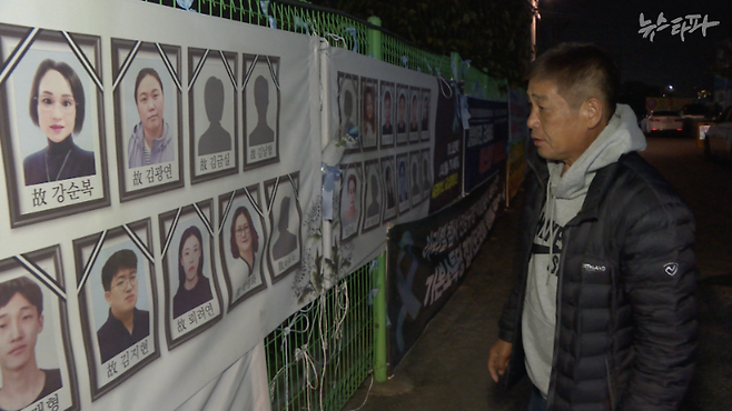 고 박영화 씨 유족 이승철 씨가 에스코넥 울타리에 걸린 참사 희생자들의 영정들을 바라보고 있다. 그는 아리셀 공장에 가족끼리 함께 일하러 갔다가 같이 사망한 사람들이 많다며 안타까워했다.