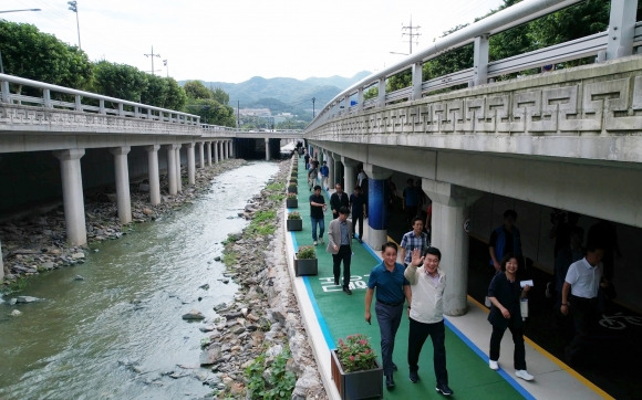 박준희(앞줄 왼쪽 두 번째) 서울 관악구청장이 지난 9월 하천 생태축으로 재탄생한 관악산에서 한강으로 이어지는 별빛내린천을 둘러보고 있다. 관악구 제공