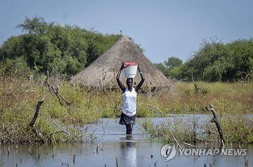홍수난 마을에서 물건 옮기는 남수단 여성(※기사와 직접 관련 없음) [AP 연합뉴스 자료사진. 재판매 및 DB 금지]