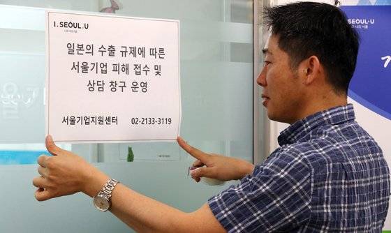 2019년 7월 서울기업지원센터에서 한 직원이 일본 수출규제에 따른 기업 피해 접수 및 상담 창구 운영 안내문을 부착하고 있다. 연합뉴스