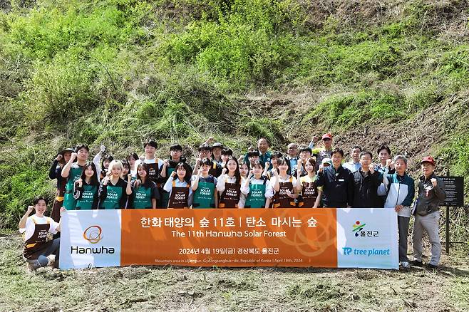 올해 조성된 울진군 '한화 태양의 숲' 부지 앞에서 임직원들이 단체 사진을 찍고 있다.