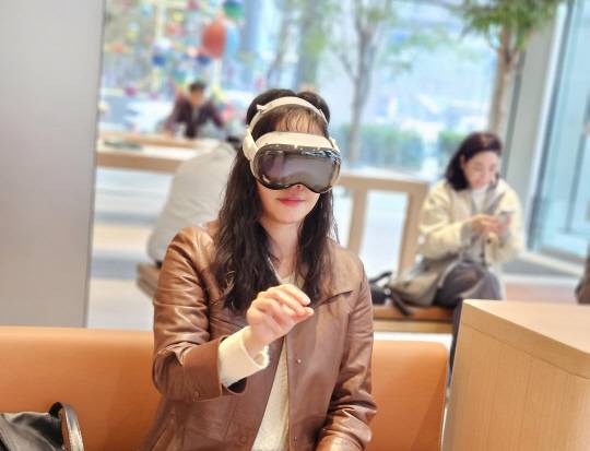기자가 애플 MR 헤드셋 '비전 프로'를 착용하고 서비스를 체험하고 있다.