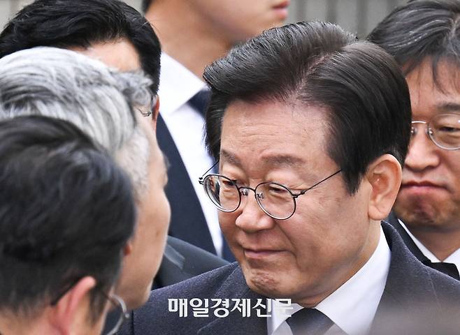 위증교사 혐의 무죄 선고를 받은 이재명 더불어민주당 대표가 25일 서울 서초동 서울중앙지방법원에서 나온 후 차에 타기 전 의원들에게 인사를 하고 있다.  공동사진취재단