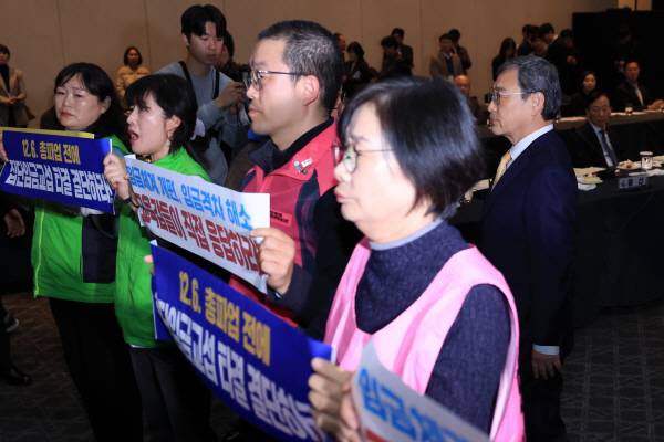 정근식 서울시교육감이 지난 21일 오후 서울 용산구 그랜드하얏트 서울 호텔에서 열린 제100회 전국시도교육감협의회 총회 시작에 앞서 피케팅하는 전국학교비정규직노동조합 조합원들과 대화를 시도한 뒤 자리로 돌아가고 있다. 연합뉴스