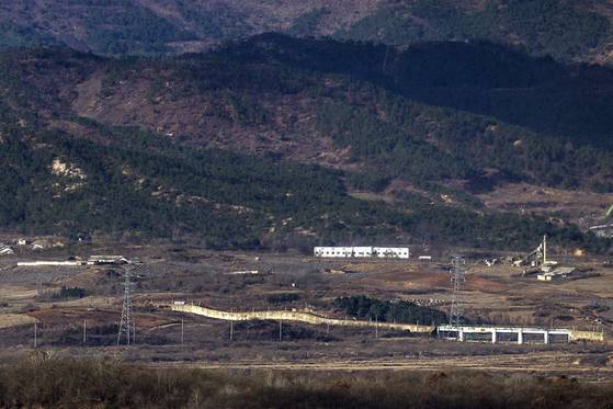Transmission towers built by South Korea to supply electricity to the now-shuttered inter-Korean Kaesong Industrial Complex in the North Korean border city of Kaesong and a barrier installed by North Korea are visible along the Gyeongui Line road in the western front demilitarized zone (DMZ) on Tuesday amid signs of North Korea preparing to dismantle some of the transmission towers linked to the complex. [YONHAP]