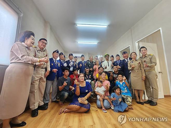 기념 촬영하는 신상태 회장과 옹의 가족 (서울=연합뉴스) 신상태 대한민국 재향군인회 회장이 26일(현지시간) 태국 아유타야 프라나콘시에서 한국전 참전 용사 옹과 가족에게 제공할 보금자리 주택 준공 및 입주식에 참석, 옹의 가족과 기념 촬영하고 있다. 2024.11.26 [대한민국재향군인회 제공. 재판매 및 DB 금지] photo@yna.co.kr