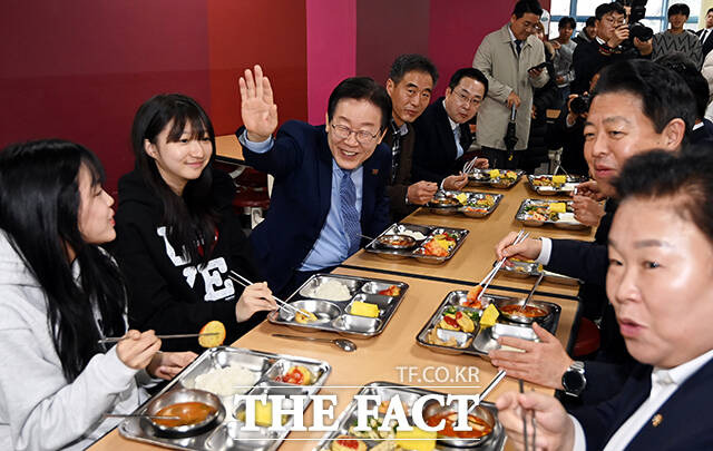 이재명 더불어민주당 대표(왼쪽 세번째)가 27일 오전 서울 성동구 금호고등학교에서 열린 '고교 무상교육을 위한 현장 간담회'를 마친 뒤 식생활 교육실에서 학생들과 인사를 하고 있다. /국회사진취재단