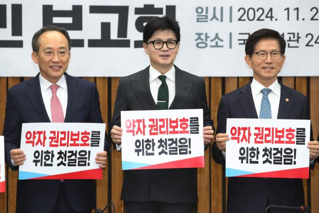 한동훈(가운데) 국민의힘 대표와 추경호(왼쪽) 원내대표, 김문수 고용노동부 장관이 26일 국회에서 열린 노동약자지원법 입법발의 국민 보고회에서 손피켓을 들고 기념 촬영을 하고 있다. 뉴스1