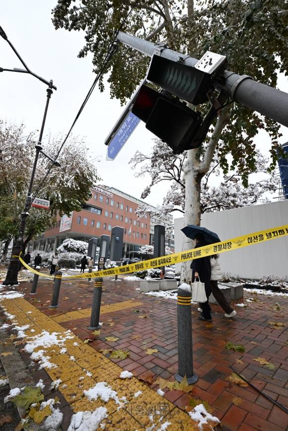 기록적인 첫 눈이 내린 27일 서울 종로구 대학로의 한 횡단보도 신호등이 기울어져 있다. 이 사고는 밤새 내린 폭설의 무게를 견디지 못하고 부러진 가로수가 신호등과 연결된 전선줄을 끌어당겨 발생했으며 인명피해는 없는 것으로 파악됐다. 2024.11.27 홍윤기 기자