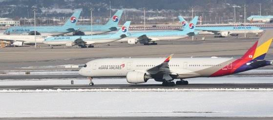 28일 인천 영종도 인천국제공항 활주로와 주기장에 대한항공-아시아나항공 여객기가 보이고 있다. 연합뉴스