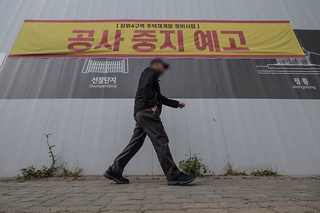 지난 21일 서울 성북구 장위4구역 재개발 공사 현장 외벽에 ‘공사 중지 예고’ 현수막과 건설사의 호소문이 게시돼 있다. /뉴스1