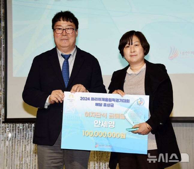 안세영을 대신해 참석한 길영아 삼성생명 감독(오른쪽)과 상금을 건네고 있는 김택규 대한배드민턴협회장. /사진=뉴시스