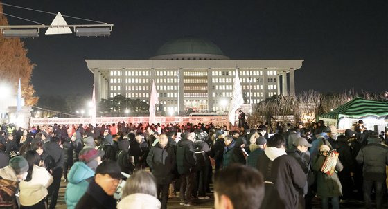 윤석열 대통령의 비상계엄 해제 요구 결의안이 국회 본회의에서 통과된 4일 새벽 서울 여의도 국회 정문 앞에 수천명의 시민들이 모여 윤 대통령을 규탄하고 있다. 전민규 기자