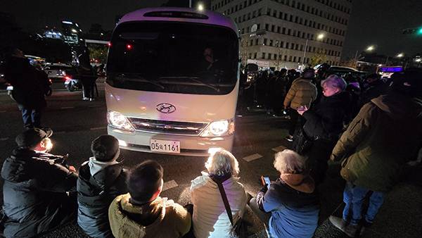 ▲3일 저녁 윤석열 대통령의 비상계엄 선포에 따라 수도방위사령부 소속 군인들이버스로 국회 정문을 통해 진입하려고 하자 시민들이 막아서고 있다. 사진=김용욱 기자