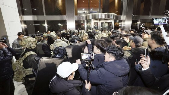 윤석열 대통령이 계엄령을 선포한 다음 날인 4일 새벽 국회로 진입하려는 군인들을 국회 보좌진과 시민들이 막고 있다. 김성룡 기자