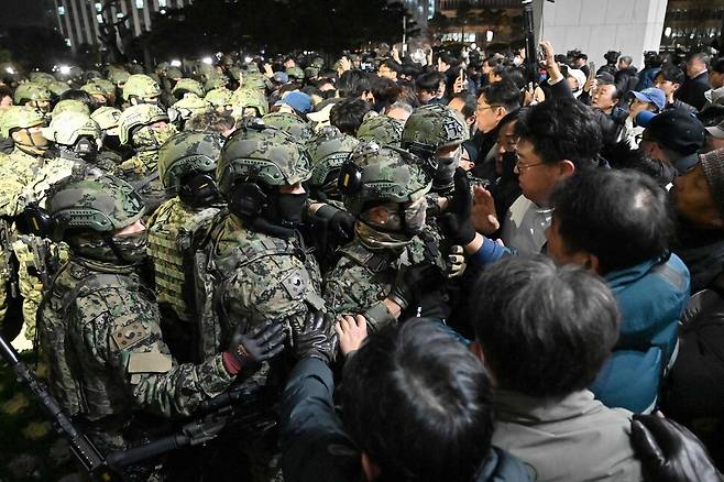 비상계엄이 선포된 이후 2024년 12월4일 새벽 군인들이 국회의사당에 들어가려 하고 있다. AFP 연합