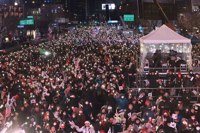 7일 서울 광화문 동화면세점 앞에서 대한민국바로세우기국민운동본부 주최로 열린 ‘주사파 척결 국민대회’ 참가자들이 김건희 여사 특검법 부결과 대통령 탄핵소추안에 관한 소식을 듣고 기뻐하고 있다. [연합뉴스]