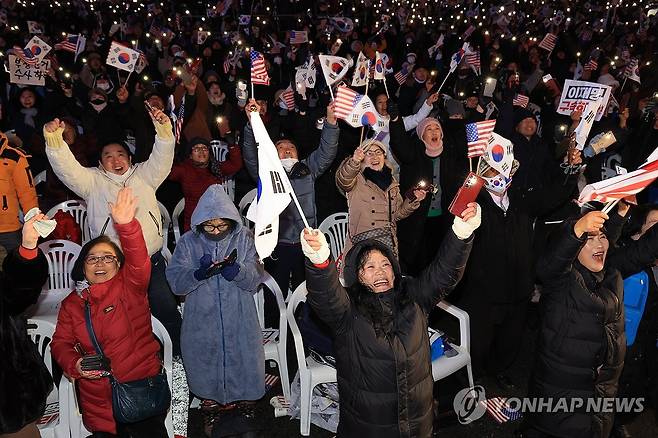 기뻐하는 보수단체 (서울=연합뉴스) 신현우 기자 = 7일 서울 광화문 동화면세점 앞에서 대한민국바로세우기국민운동본부 주최로 열린 '자유 대한민국 수호 광화문 국민혁명대회' 참가자들이 김건희 여사 특검법 부결과 대통령 탄핵소추안에 관한 소식을 듣고 기뻐하고 있다. 2024.12.7 nowwego@yna.co.kr