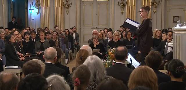 7일 오후 스웨덴 한림원 그랜드홀에서 한강의 소설 ‘작별하지 않는다’의 한 구절을 스웨덴·영국에서 활동하는 배우 조 라이드아웃(Jo rideout)이 영어 낭독하고 있다. 왼쪽 객석에서 한강 작가가 경청하고 있다. 노벨상 공식 유튜브 갈무리