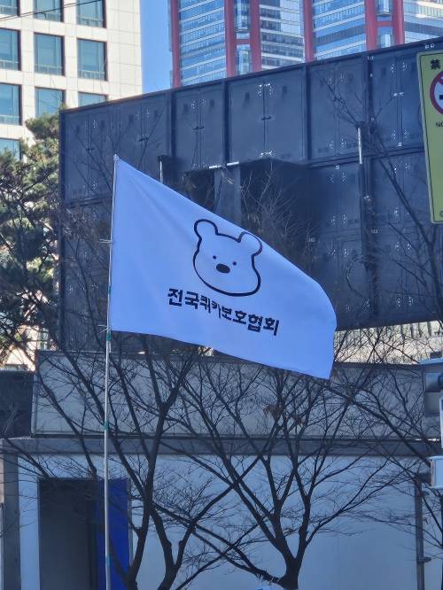 8일 서울 영등포구 국회의사당 앞에서 윤석열 대통령 규탄 집회에 참여한 시민들이 ‘전국쿼카보호협회’가 적힌 깃발을 들고 시위에 참여하고 있는 모습. 유규상 기자