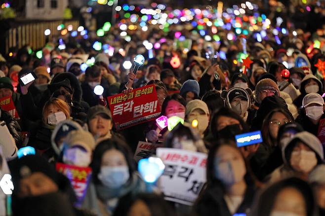 지난 8일 오후 서울 여의도 국회 앞에서 열린 윤석열 탄핵 및 구속을 촉구하는 촛불문화제에서 참가자들이 관련 손팻말과 응원봉을 들고 있다. ⓒ연합뉴스