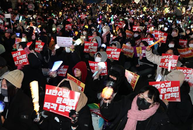 지난 9일 오후 서울 영등포구 국회의사당 앞에서 열린 ‘윤석열 즉각 탄핵 구속 촉구 촛불문화제’에서 참가자들이 손팻말을 들고 있다. 연합뉴스