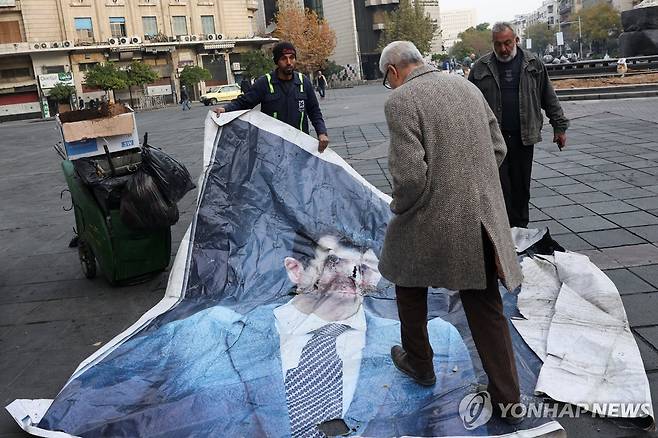 알아사드 대통령 초상화 짓밟는 남성 (다마스쿠스 로이터=연합뉴스) 10일(현지시간) 한 남성이 시리아 수도 다마스쿠스에서 알아사드 대통령의 초상화를 짓밟고 있다. 2024.12.10