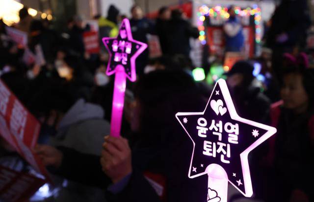 9일 오후 인천 미추홀구 농수산물시장사거리에서 열린 '내란주범 윤석열 즉각 체포! 윤석열 탄핵! 국민의힘 해체! 사회대개혁 쟁취! 인천시민촛불' 집회에서 시민들이 팻말과 응원봉을 들고 있다. 뉴시스