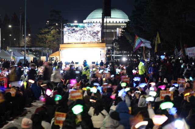 ▲9일 오후 서울 영등포구 국회의사당 앞에서 열린 '윤석열 즉각 탄핵 구속 촉구 촛불문화제'에서 참가자들이 손팻말을 들고 있다. ⓒ연합뉴스