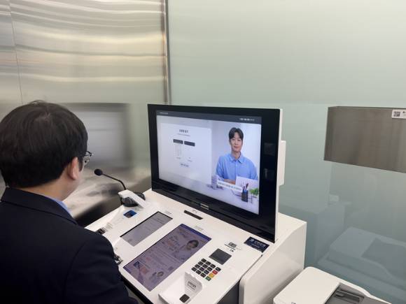 한 고객이 AI 뱅커와 상담하고 있다. [사진=신한은행]