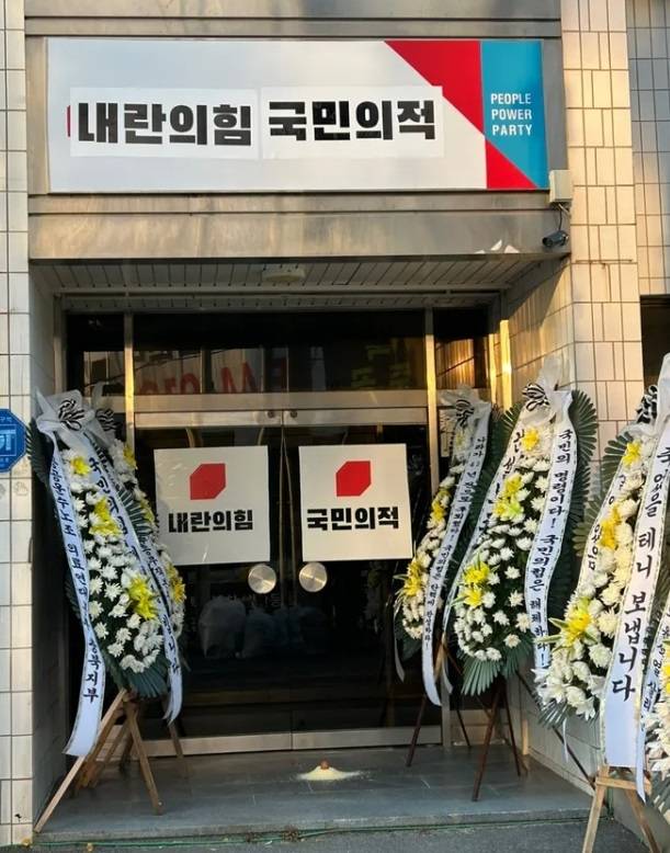 ▲ 충북시국회의가 12일 국민의힘 충북도당 간판과 입구에 '내란의힘', '국민의적'이라고 쓰인 인쇄물을 붙였다. [충북시국회의]