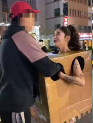 알몸에 박스만 걸친 채 행인들에게 자신의 신체를 만지도록한 20대 여성이 1심에서 벌금형을 선고받았다. /사진=온라인 커뮤니티 캡처