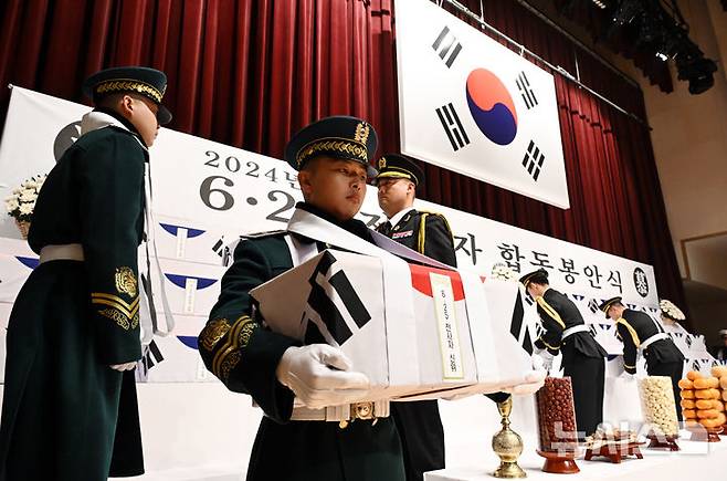 [서울=뉴시스] 이영환 기자 = 12일 오전 서울 동작구 국립서울현충원 현충관에서 열린 2024년 6.25 전사자 합동봉안식에서 국군 의장대가 영현을 봉송하고 있다. (공동취재) 2024.12.12. photo@newsis.com