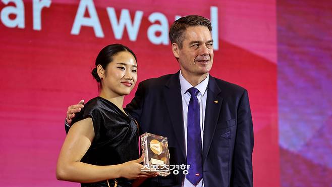 안세영이 9일 BWF 시상식에서 올해의 여자선수상을 수상한 뒤 폴-에릭 호야 BWF 회장으로부터 상패를 받고 기념촬영 하고 있다. BWF 홈페이지 캡처