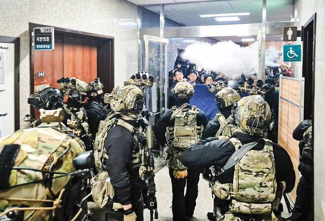 윤석열 대통령이 지난 3일 밤 비상계엄을 선포한 이후 무장 계엄군이 국회의사당 본청에 진입하고 있다. 국회 당직자와 보좌진들은 통로에 집기를 쌓아 방어선을 만들고 소화기를 뿌리며 막아섰다. 연합뉴스