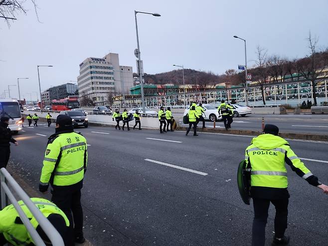 12일 오후 대통령 공관을 향해 시위대가 뛰어가자 경찰이 왕복 10차선 도로를 가로질러 따라가고 있다. 이영기 기자.