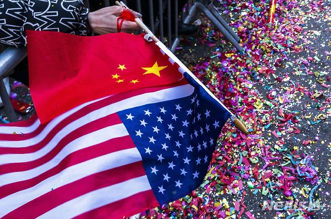 [뉴욕=AP/뉴시스] 미국 뉴욕 맨해튼의 차이나타운에서 설날을 기념하는 용 퍼레이드가 열려 한 참가자가 미국과 중국 국기를 흔들고 있다. 2024.02.26.