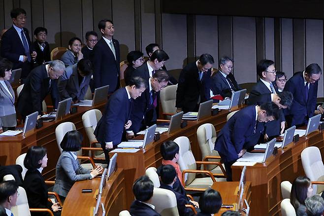 12월 11일 오후 서울 여의도 국회에서 열린 12·3 비상계엄 사태 관련 긴급현안질문에 출석한 최상목 경제부총리 겸 기획재정부 장관과 이주호 사회부총리 겸 교육부 장관 등 국무위원들이 서영교 더불어민주당 의원의 계엄 사태와 관련해 사과를 요구하자 고개를 숙이고 있다. [뉴시스]