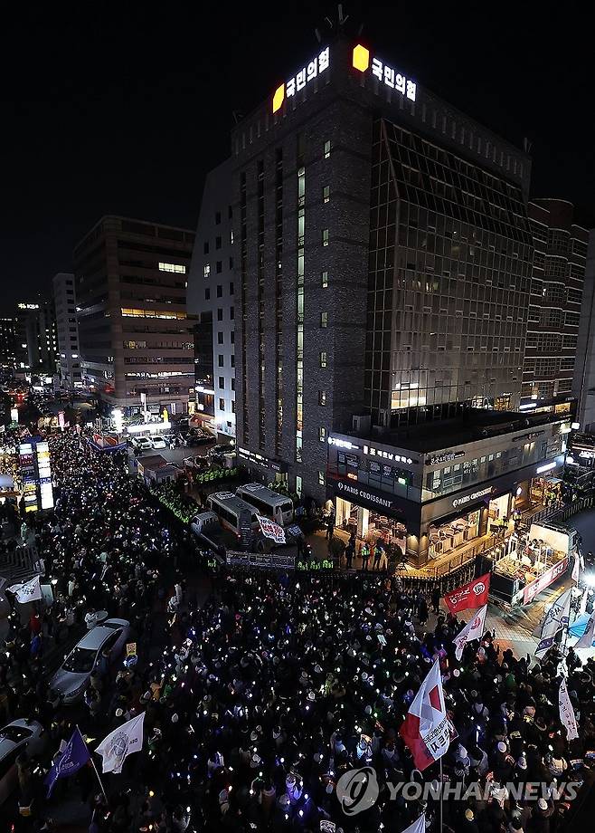 국민의힘 당사 에워싼 시민들 (서울=연합뉴스) 김성민 기자 = '윤석열 즉각 퇴진·사회대개혁 비상행동'이 13일 오후 서울 영등포구 국회의사당 인근에서 연 탄핵소추안 국회 통과 촉구 촛불집회에서 참가자들이 국민의힘 당사로 행진해 구호를 외치고 있다. 2024.12.13 ksm7976@yna.co.kr