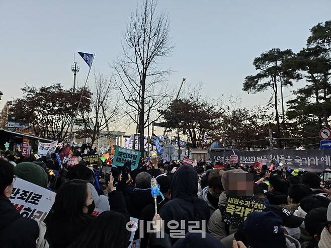 윤석열 대통령에 대한 탄핵소추안이 국회에서 가결된 14일 서울 여의도 국회 앞에 모인 시민들이 환호성을 보내고 있다. (사진=김형환 기자)