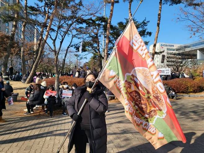 남모씨가 ‘햄버거 사랑 동호회’ 깃발을 들고 있다. 심성아 기자