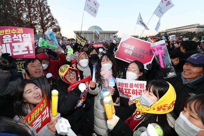 윤석열 대통령 탄핵안이 가결된 14일 서울 여의도 국회의사당 앞에서 집회에 참여한 시민들이 윤 대통령의 탄핵 소식을 듣고 기뻐하고 있다. 2024.12.14 /박성원 기자